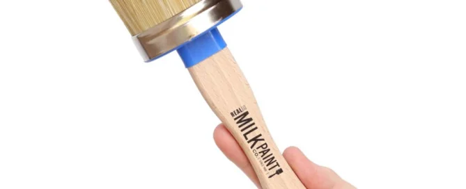 Hand holding up a wax brush