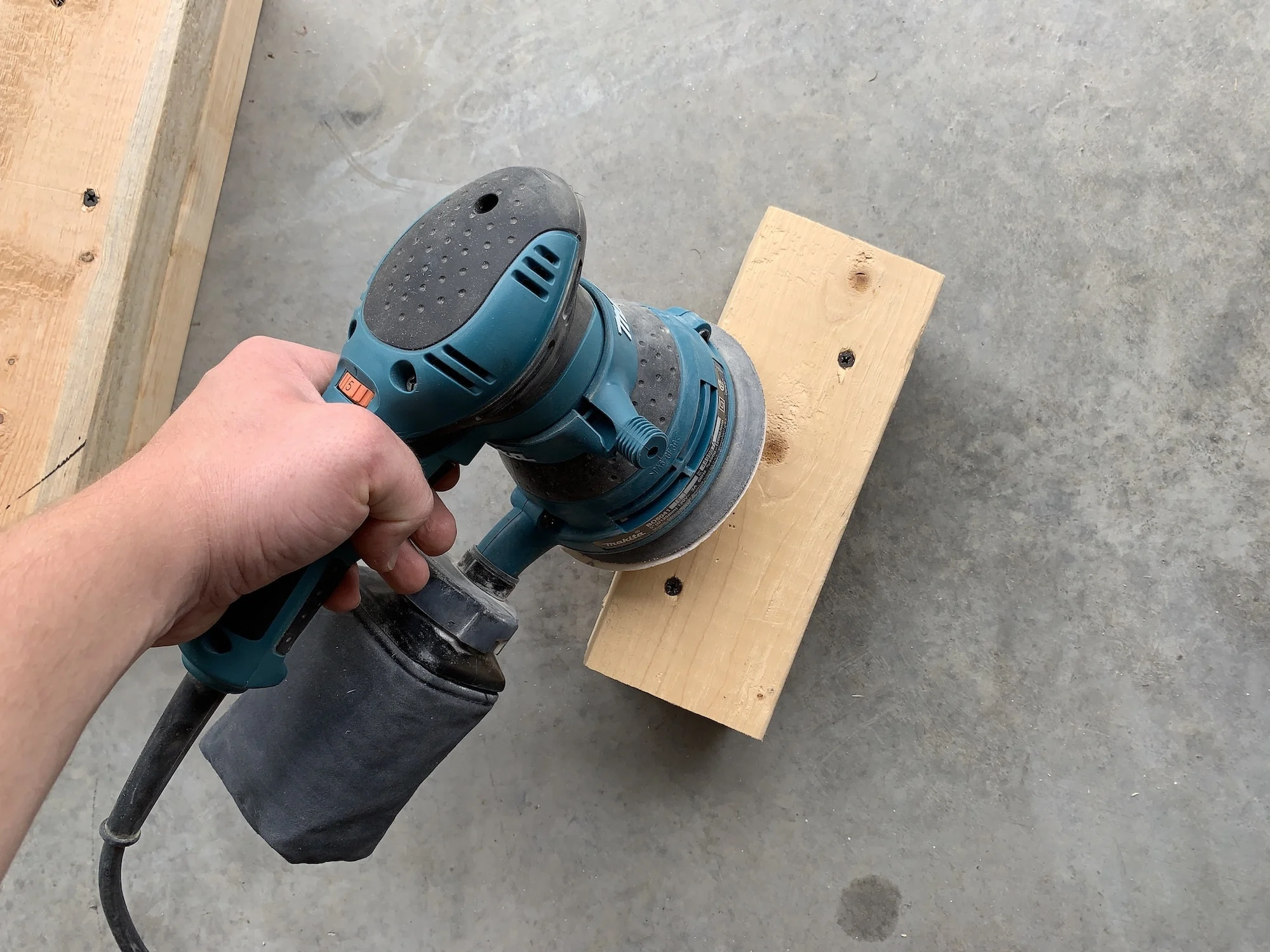a man sanding wood, opening the pores to pickle wood with milk paint