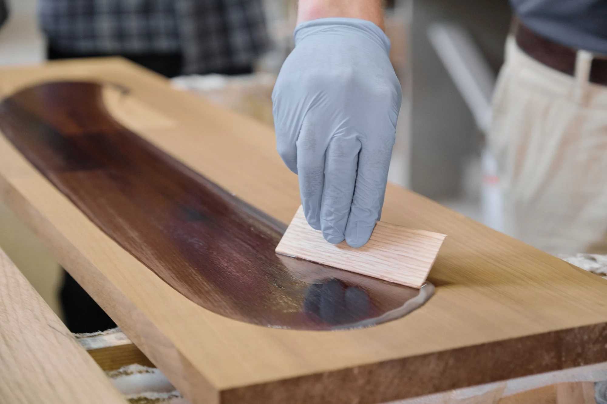 man working on a DIY noodle board stained with a darker color than the original hardwood