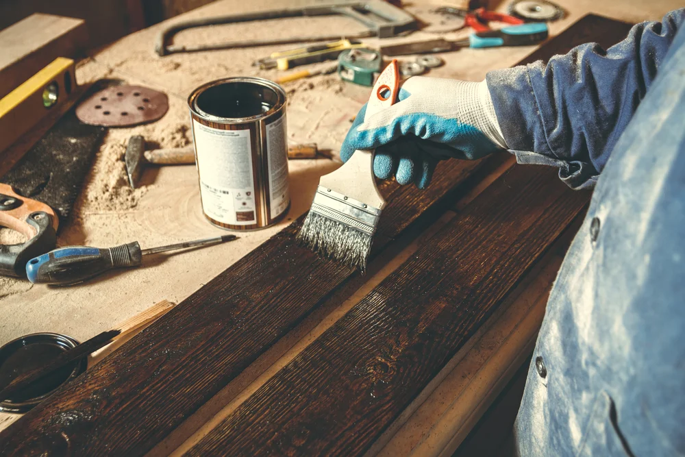 man using varnish for his outdoor project