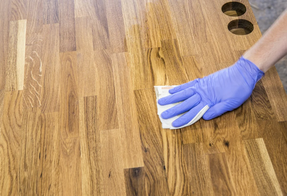 Close up view of oil application - avoid using mineral oil for wood surfaces Close up view of oil application - avoid using mineral oil for wood surfaces