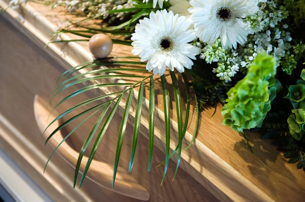 Floral arrangement placed on a biodegradable casket made from natural materials for an eco-conscious farewell