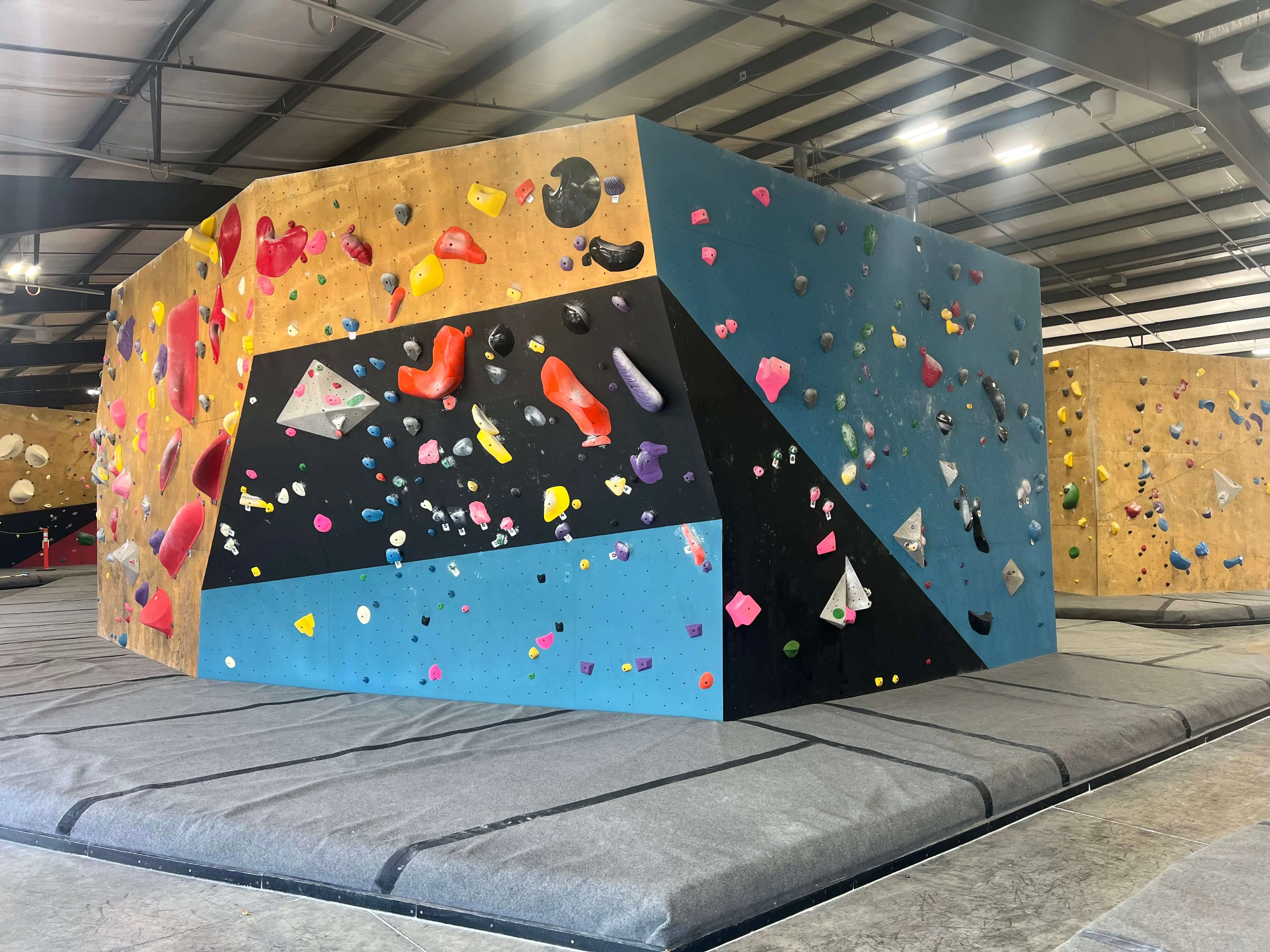 A view of the refurbished climbing walls at Circuit Gym, showing solid, clean colors and freshly textured grip surfaces.
