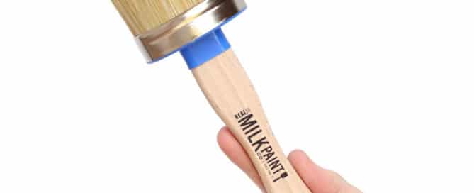 Hand holding up a wax brush