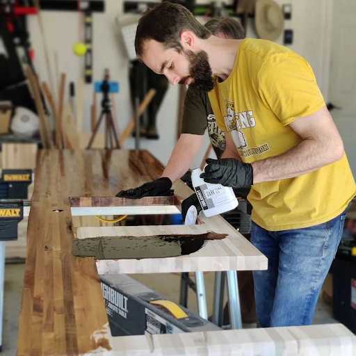 a man applying a protective coat after wood staining