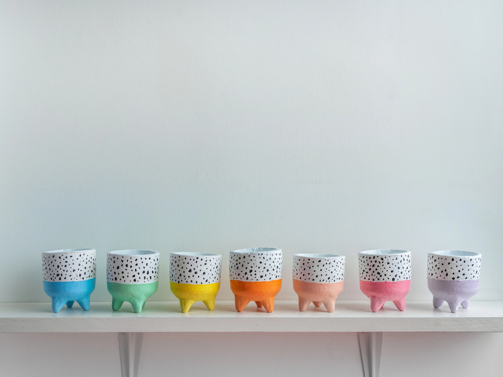 Modern indoor decor featuring hand painted terracotta pots in rainbow colors