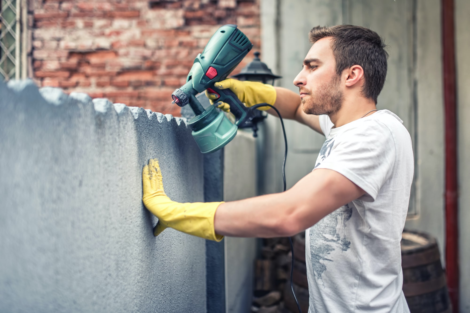 man spraying paint on wall