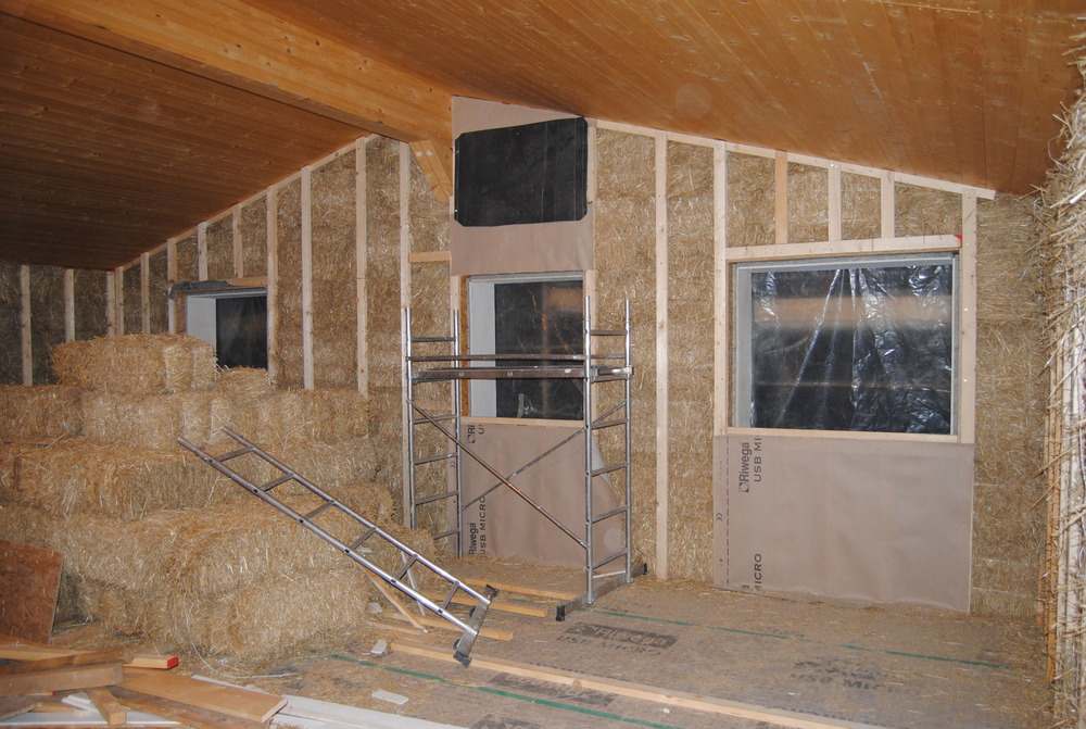 straw bale house still with loose straw and under construction