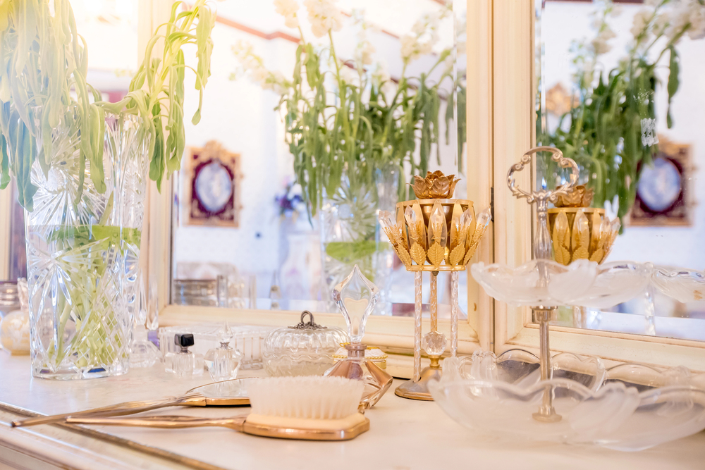 Vintage style home decor ideas with ornate gold candle holders, crystal vases, and antique vanity accents